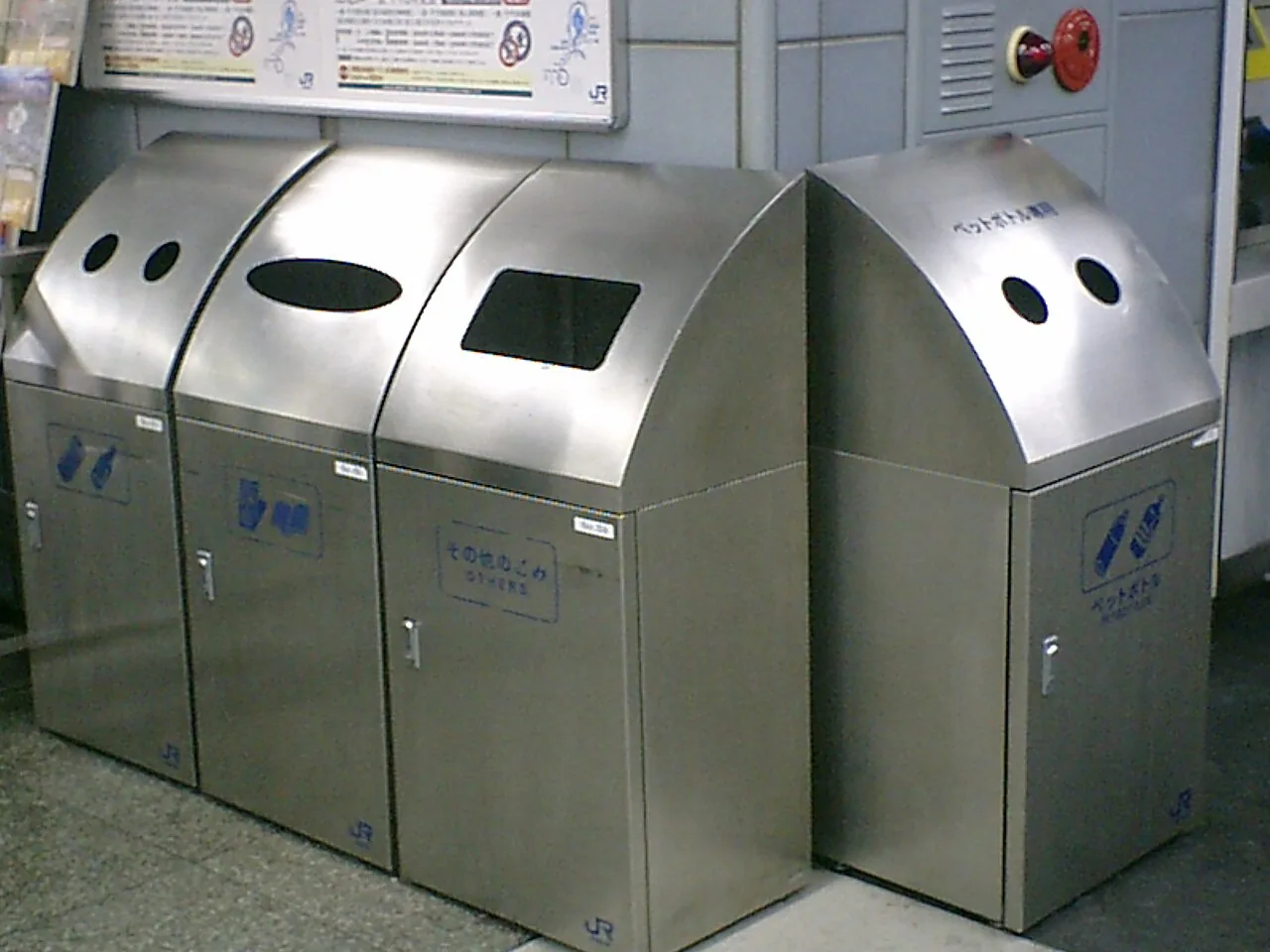 Three metal station bins side by side, with round holes on two of them and a slot on the third