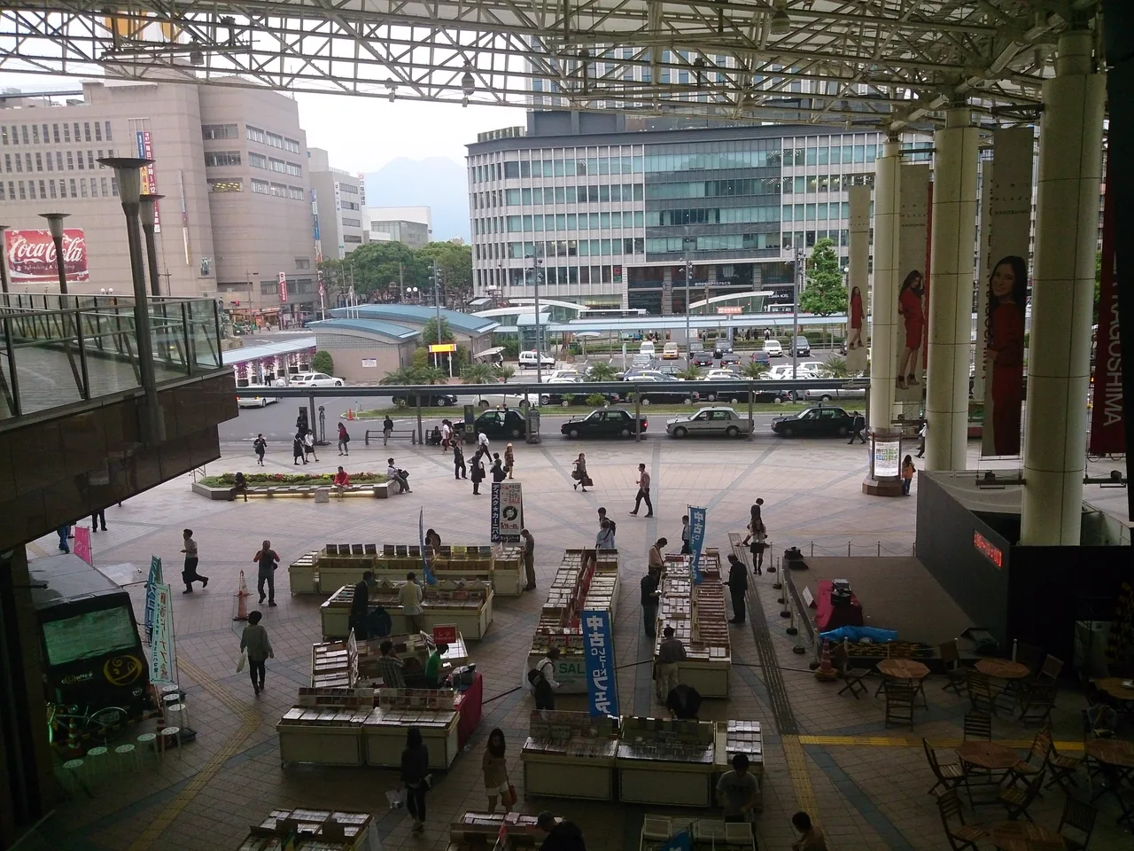 The open square in front of Kagoshima-Chuo Station, with pillars in the foreground and buildings behind
