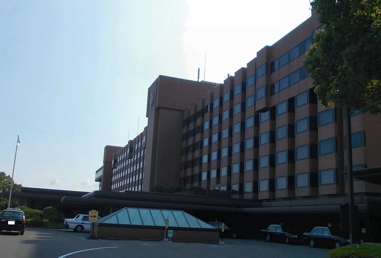 The long brown facade of the hotel on Shiroyama hill, with the access road running past it