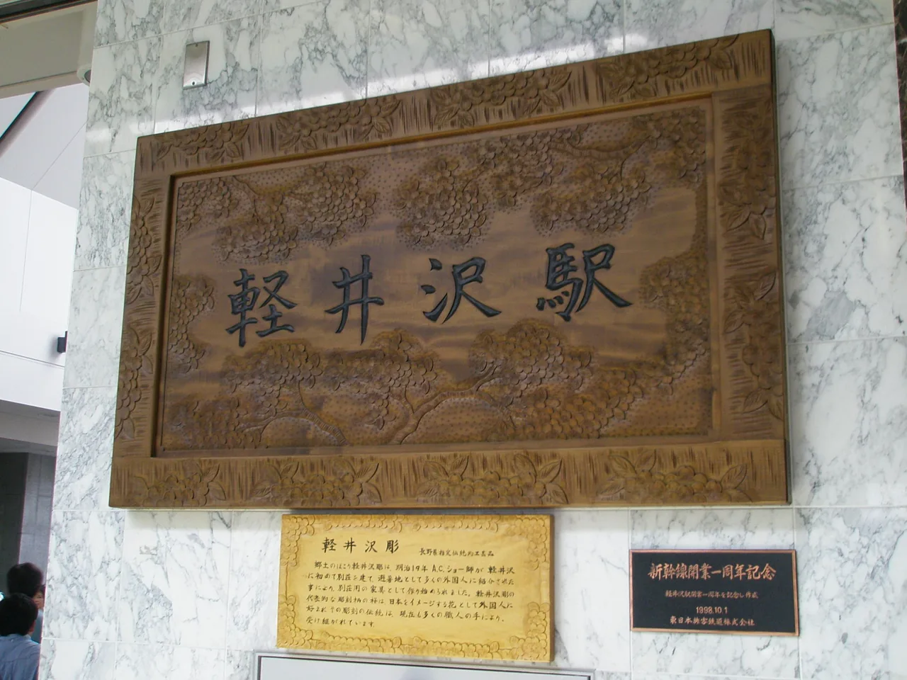 A wooden station nameplate with the characters carved in relief