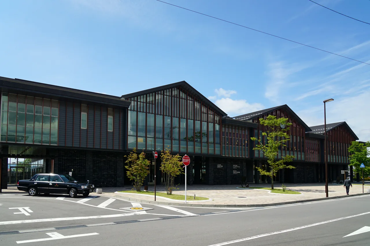 A long low station building with a glass frontage beside an empty road