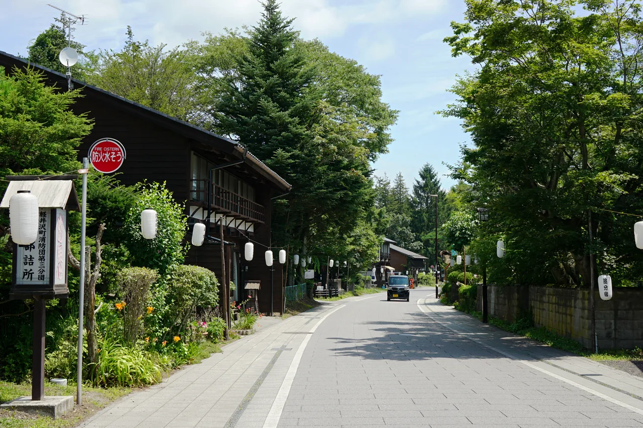 A quiet street of low old buildings with a mountain at the end of it