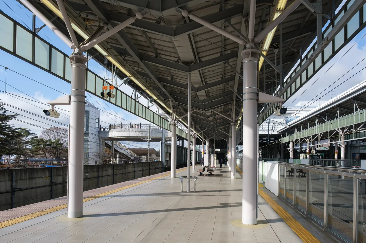 An empty Shinkansen platform under a curved roof