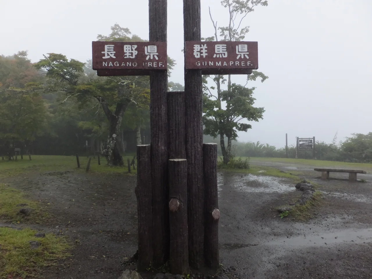 Two signposts at a misty lookout, one marked Nagano and the other Gunma