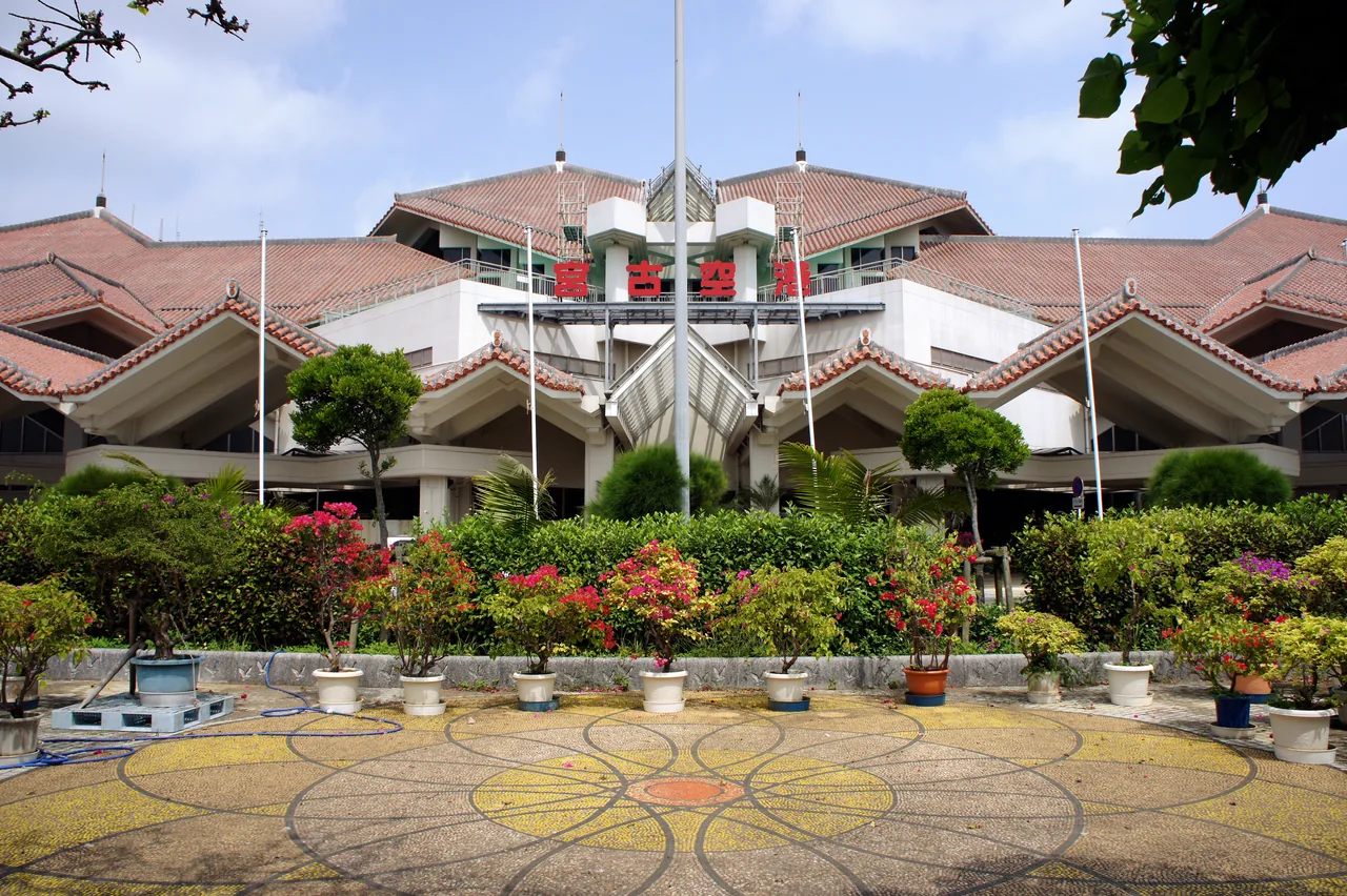The terminal building at Miyako Airport, a low structure with a tiled Ryukyu roof and flagpoles in front