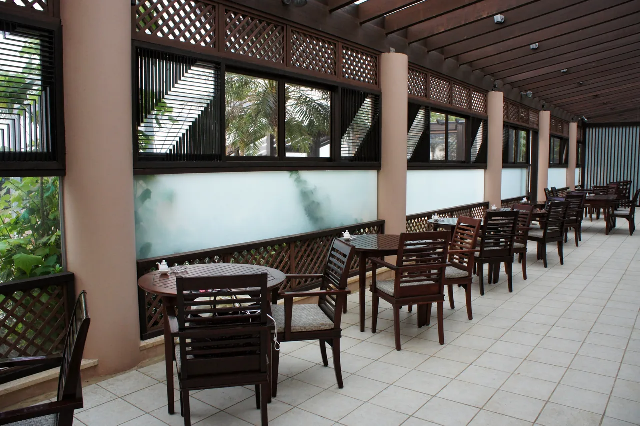 A covered terrace inside the Shigira resort on Miyakojima, with tables and chairs set along an open wall