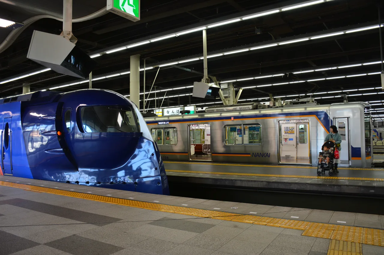 A dark blue limited express train standing at a platform at Namba station