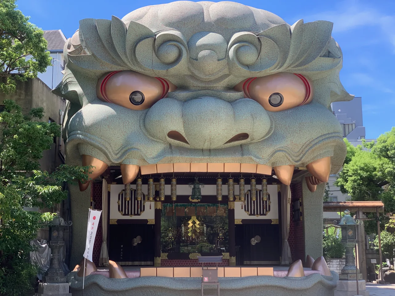 A shrine building shaped like a giant lion head with its mouth open onto the courtyard