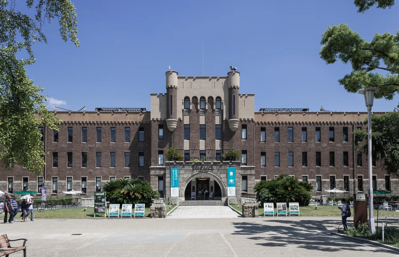 A symmetrical stone building with a central tower, three storeys high