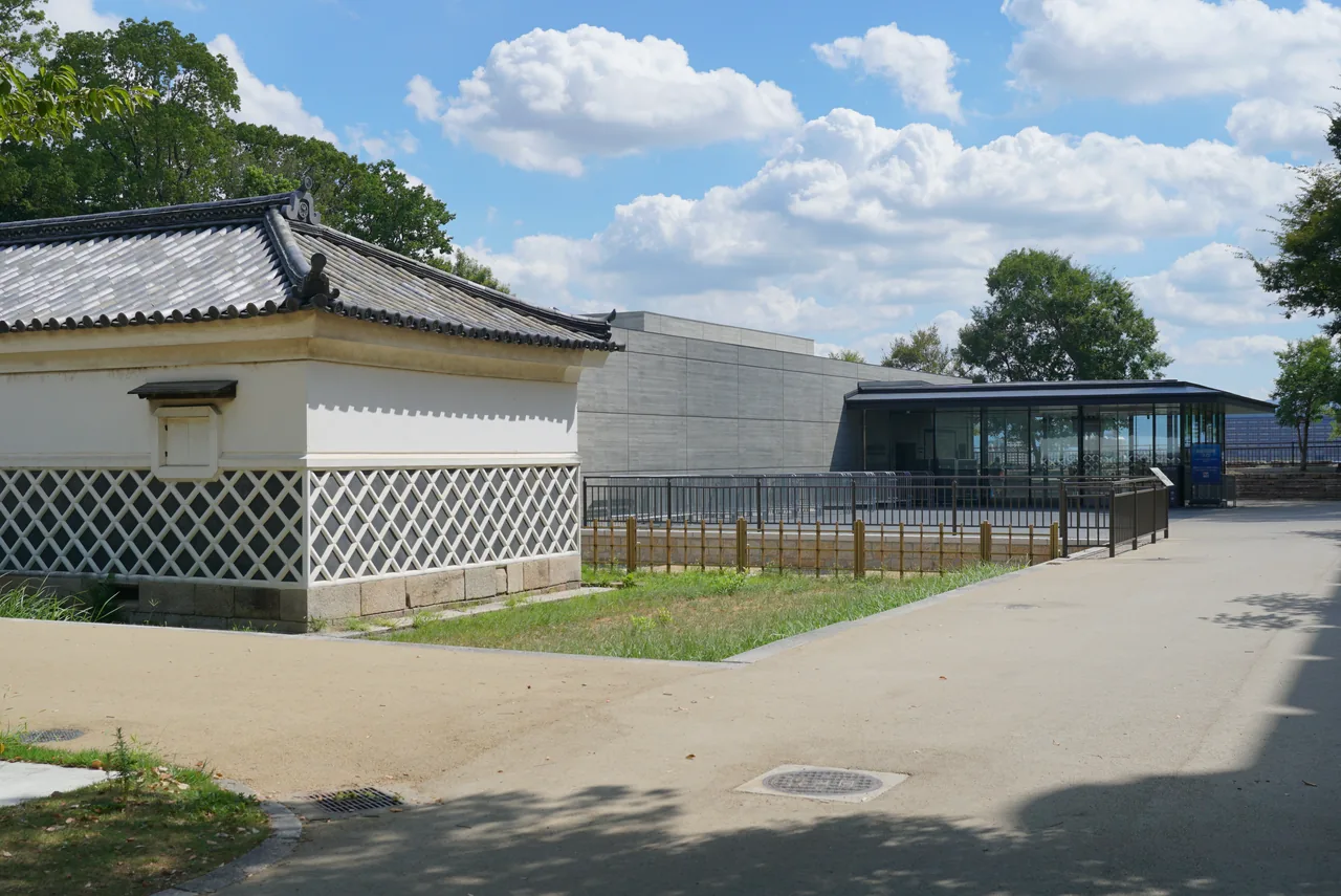 A low white and glass building standing on its own with a paved path in front