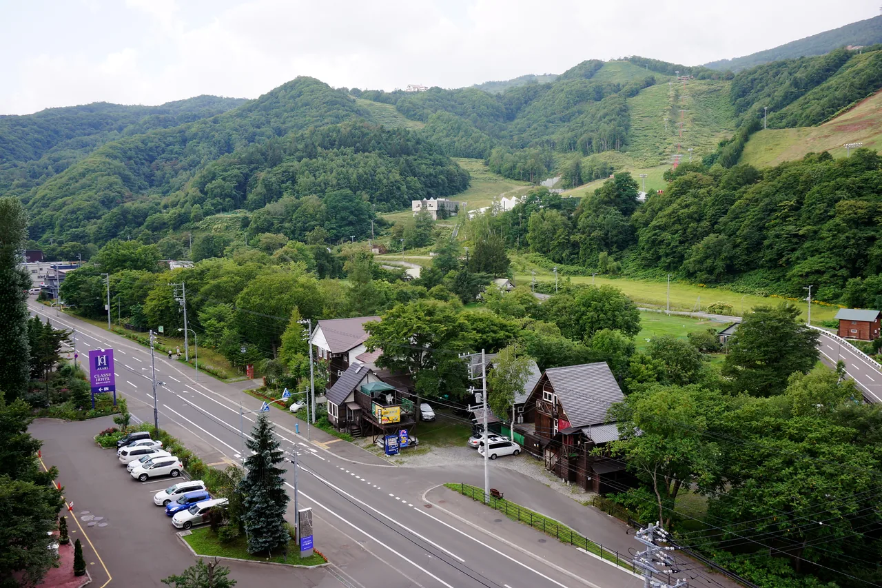 Hot-spring village in a valley surrounded by green hills in summer
