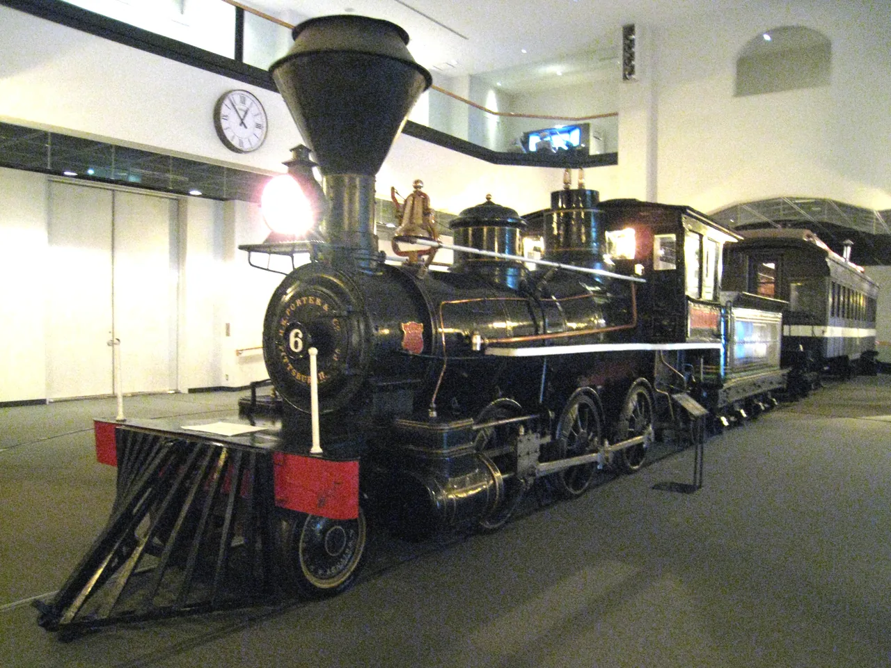 Black 19th-century steam locomotive on display indoors