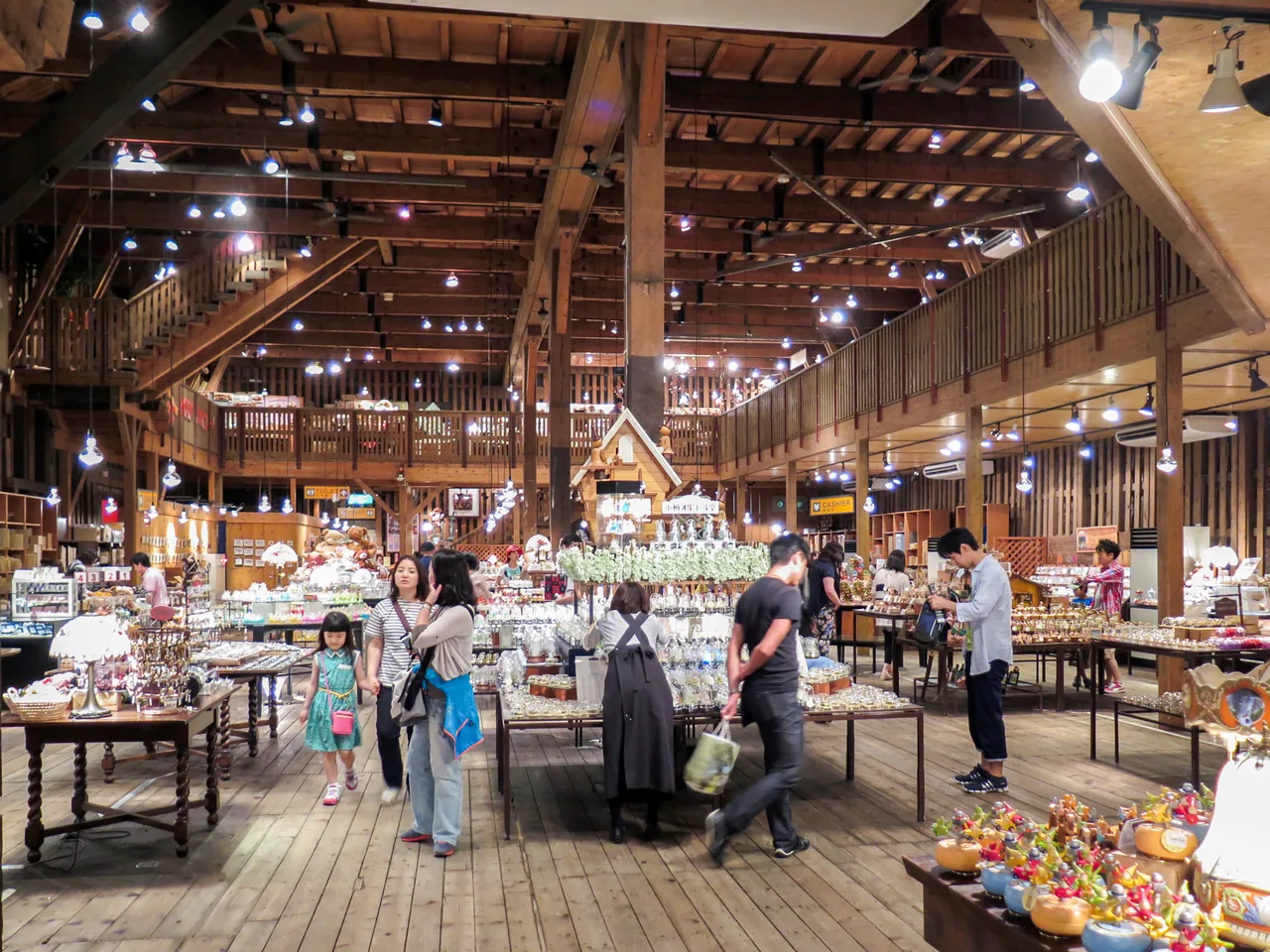 Music boxes displayed under timber beams with shoppers browsing