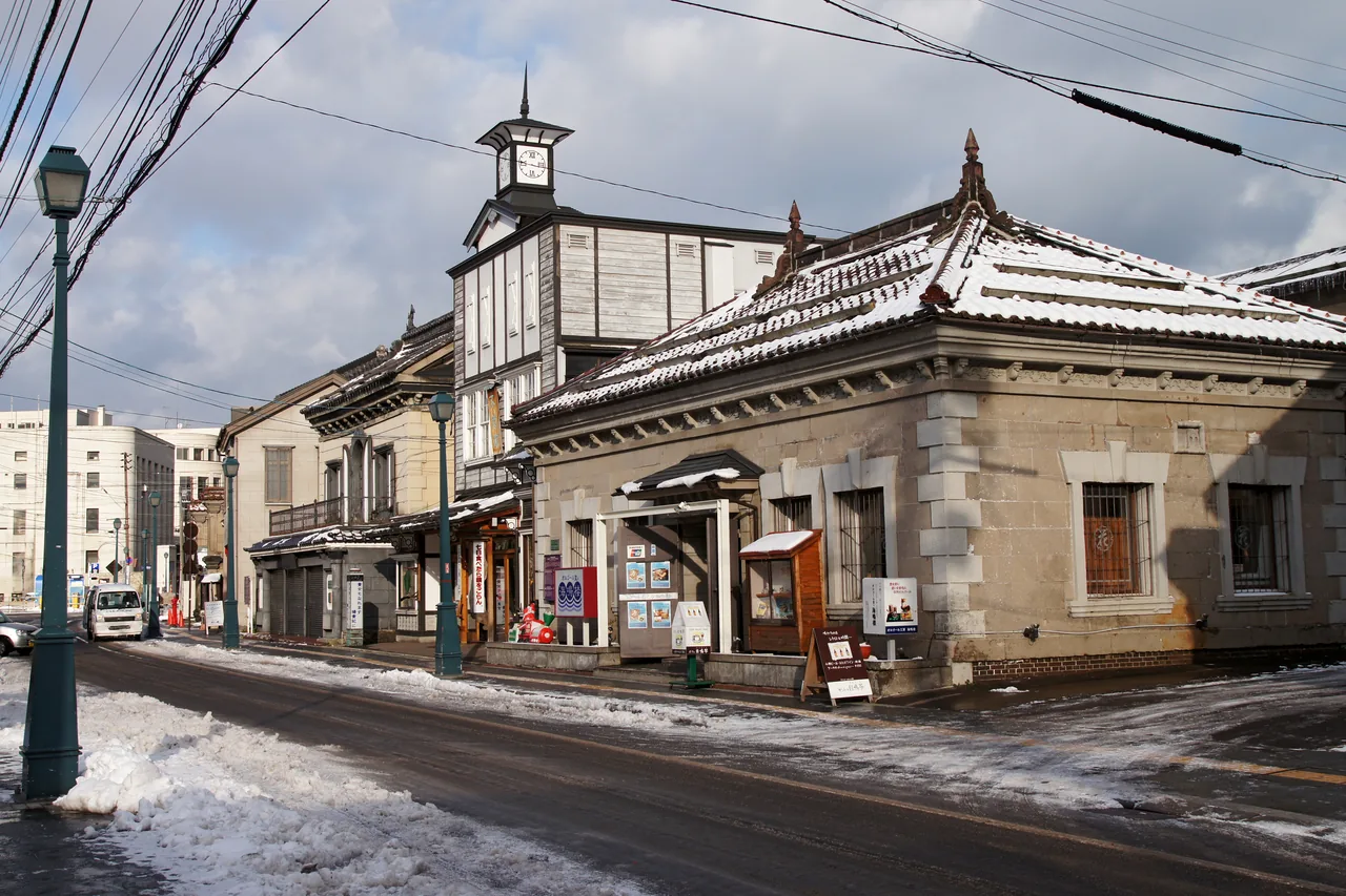 Sakaimachi Street with a little snow left, old stone and timber shopfronts and street lamps