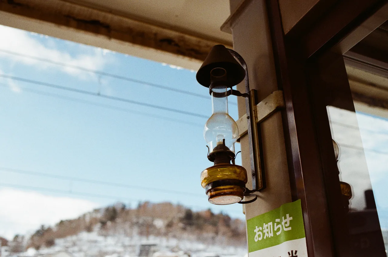 Lamp hanging over the platform at Otaru Station with snowy hills behind