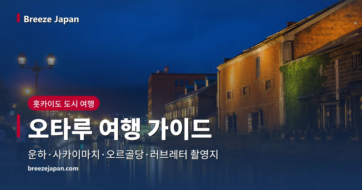 해 질 녘 푸른 하늘 아래 불이 켜진 붉은 벽돌과 석조 창고, 운하 수면에 비친 불빛