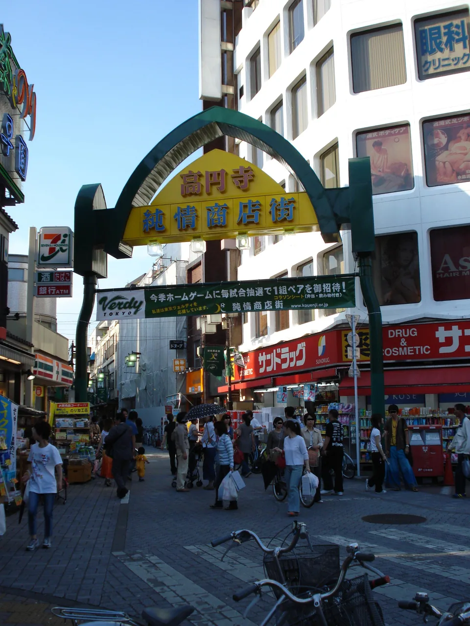 The arched gate of the Koenji Junjo shopping street with people walking underneath
