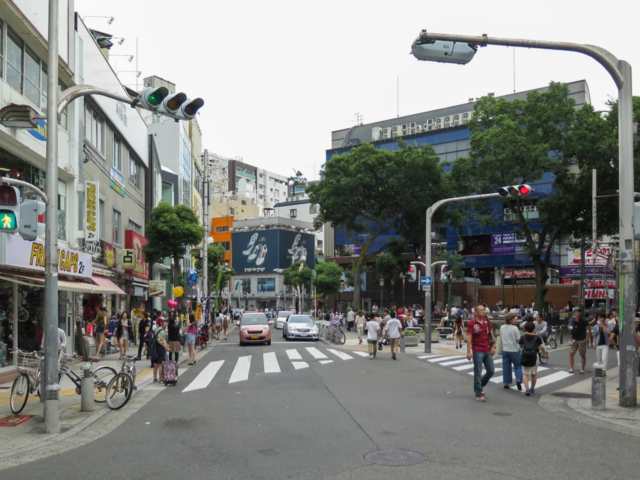 A busy crossing in Amerikamura in Osaka with shops and signs on both sides