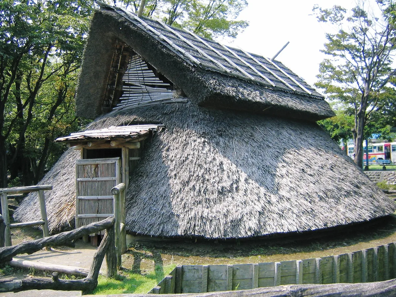 A reconstructed thatched building standing on the Toro archaeological site