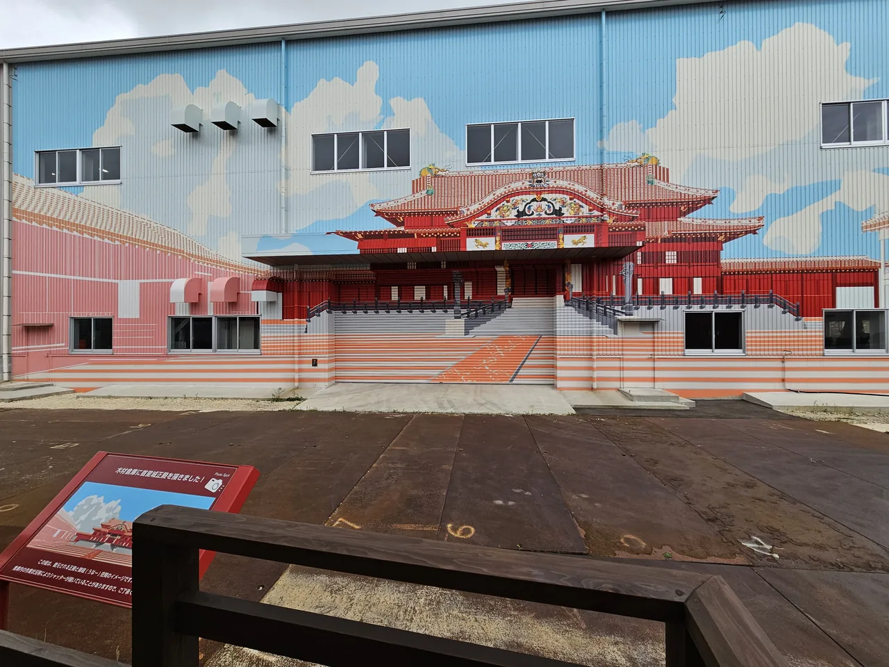A large temporary hangar at Shuri Castle with a full-size picture of the main hall printed on its outer wall