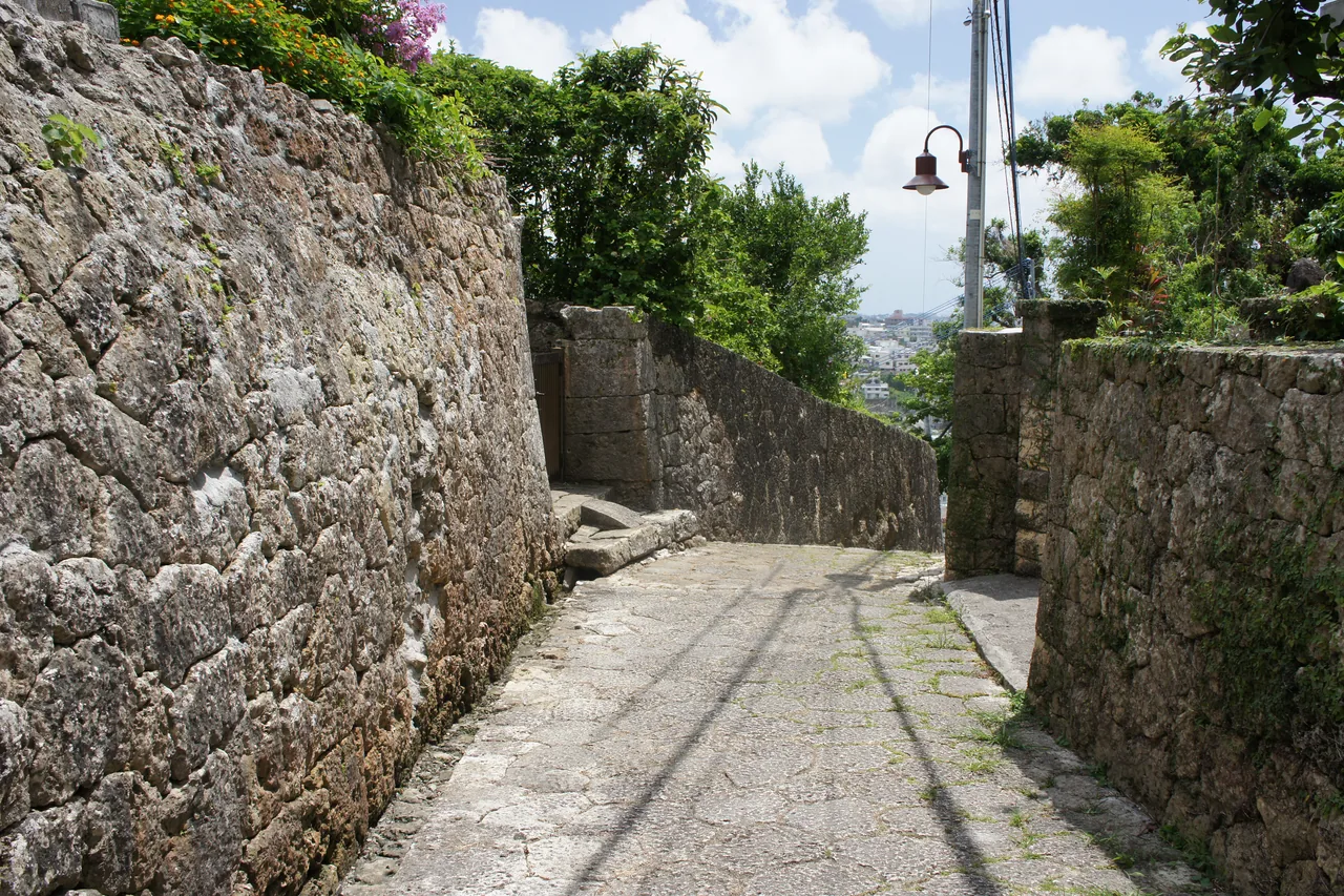 A narrow lane of worn paving stones running downhill between old stone walls