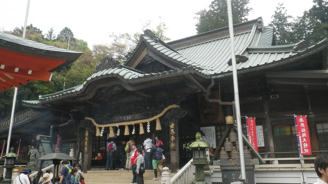 The main hall of Yakuo-in temple on Mt Takao with visitors standing in front of it