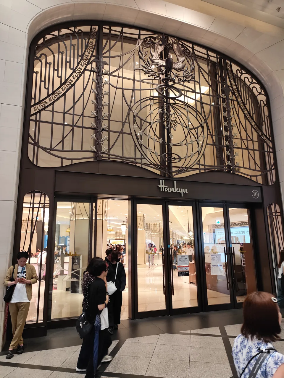 People walking past a glass-fronted entrance to a shopping complex