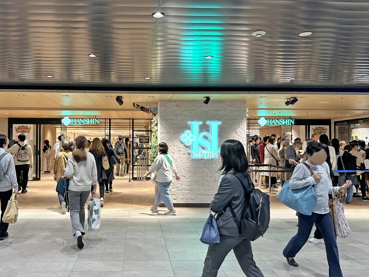 Shoppers walking in and out of a department store entrance at street level