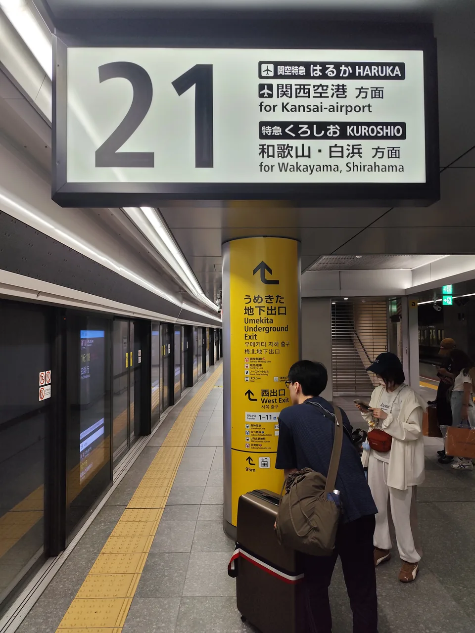 An underground railway platform with a sign reading platform 21 for Kansai Airport