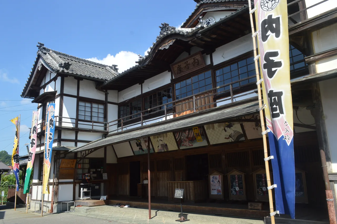 The front of Uchiko-za, a two-storey wooden theatre with 内子座 banners